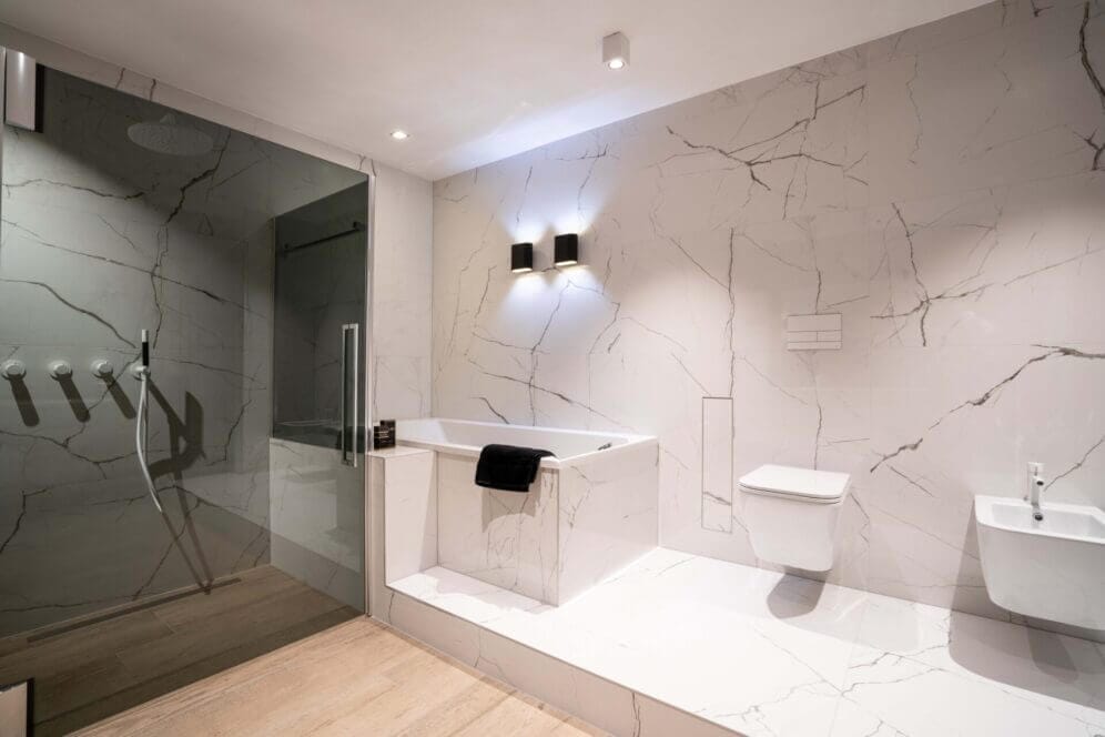 Bathroom with white marble walls and white luminaires at the ceiling