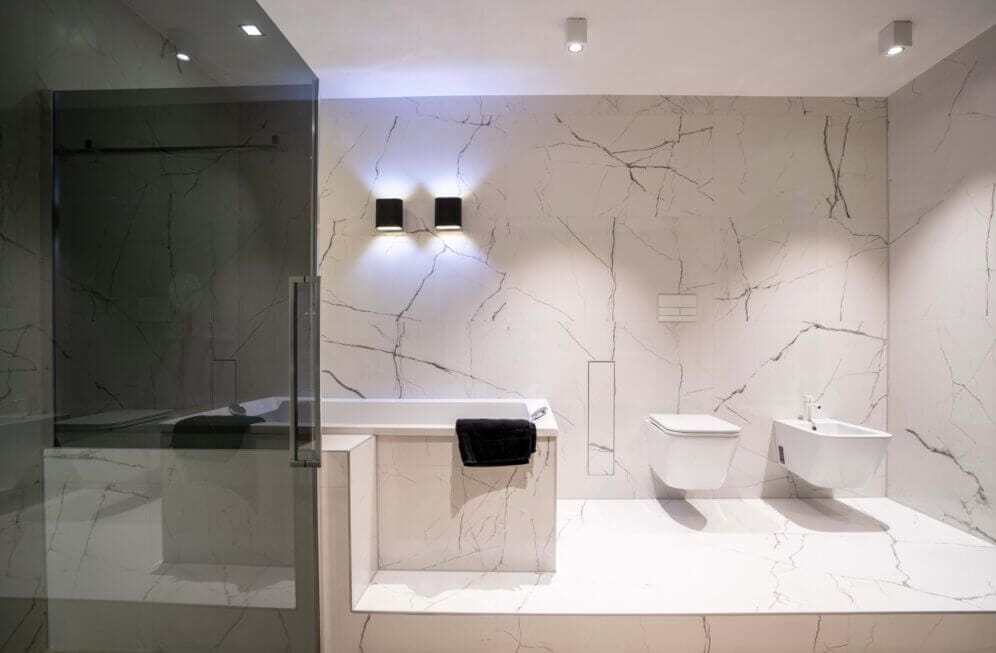 Bathroom with white marble walls and white luminaires at the ceiling