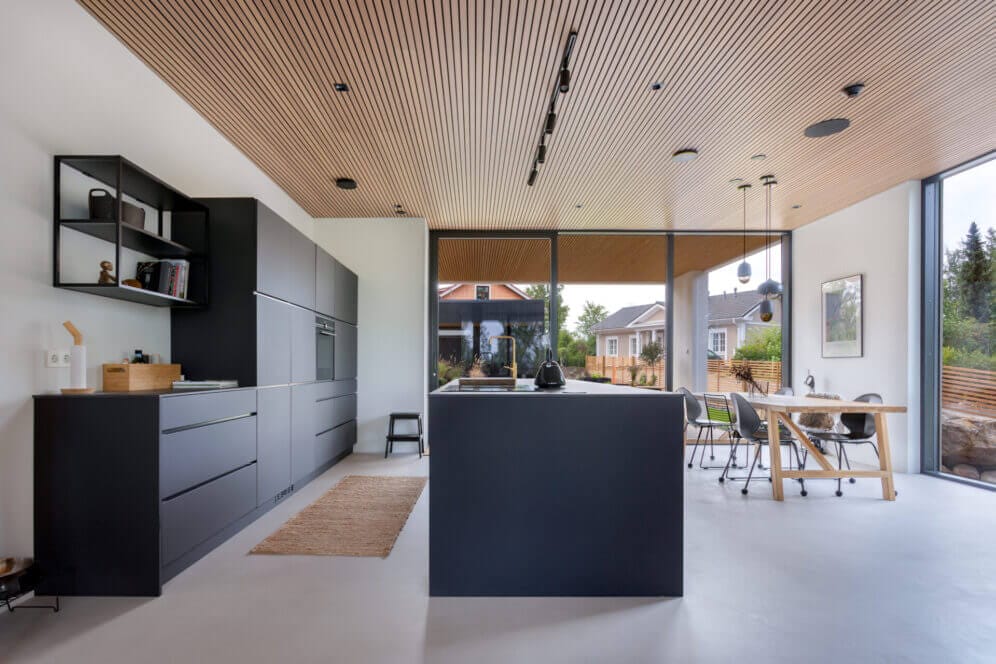 Black kitchen with wooden ceiling and big windows