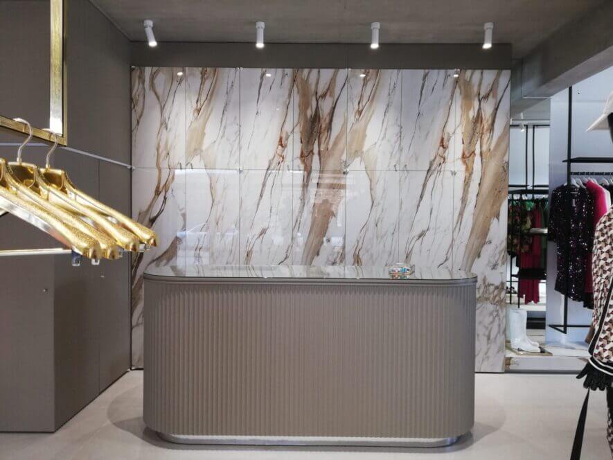 Beige counter at shop with marble wall and white spots
