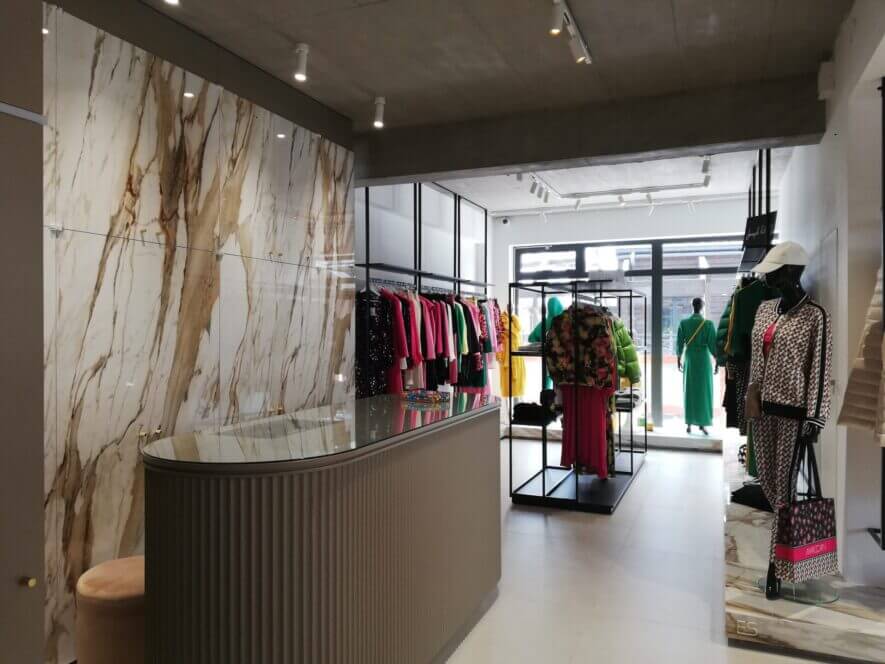 View of shop from counter, clothes in the store and window
