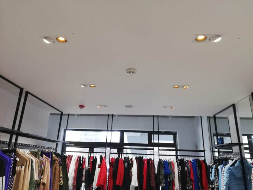 ceiling in clothing store with with spots and gold reflector