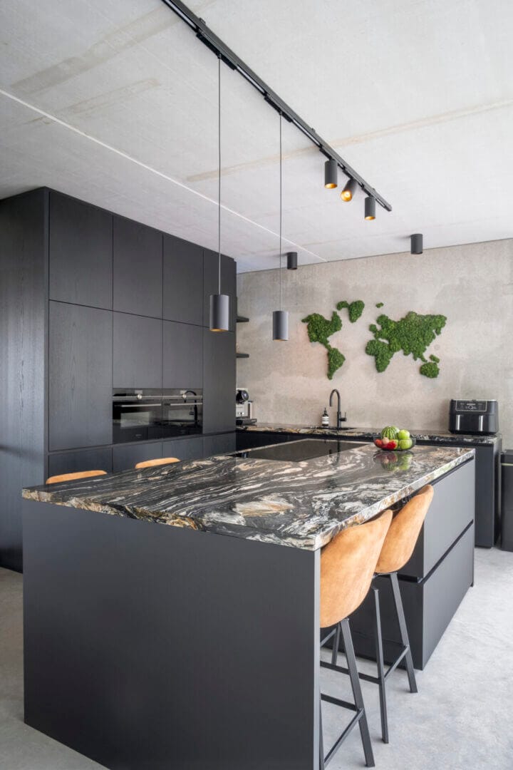Kitchen with dark cabinets and dark marble countertop.