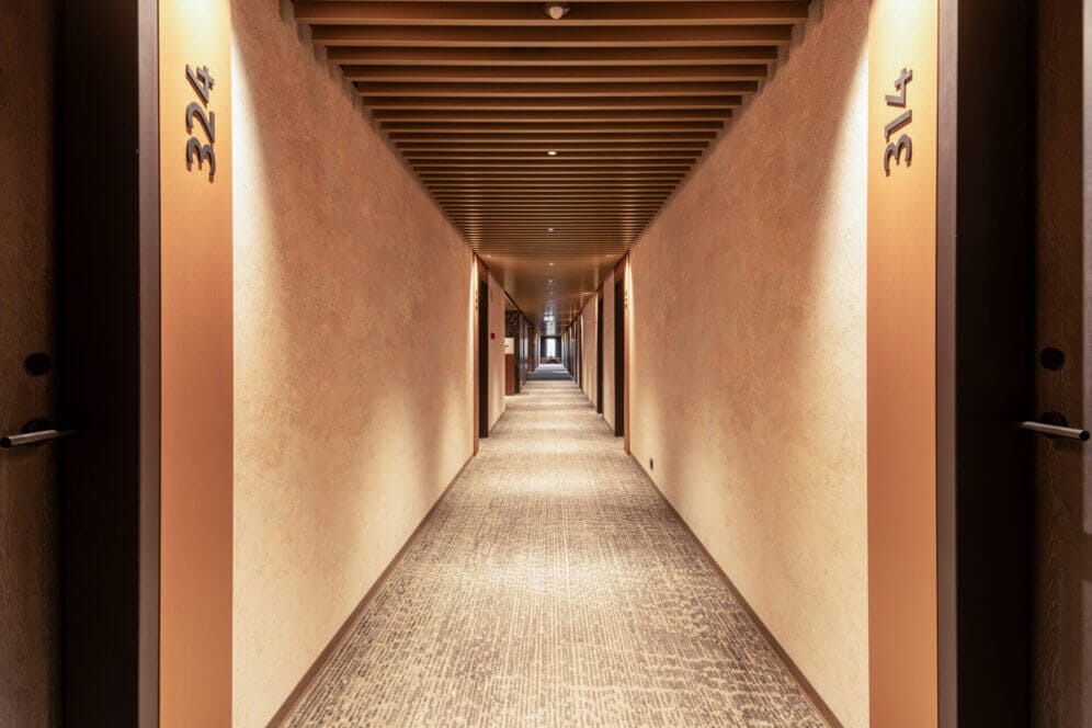 Hallway with carpet and wooden panels on ceiling