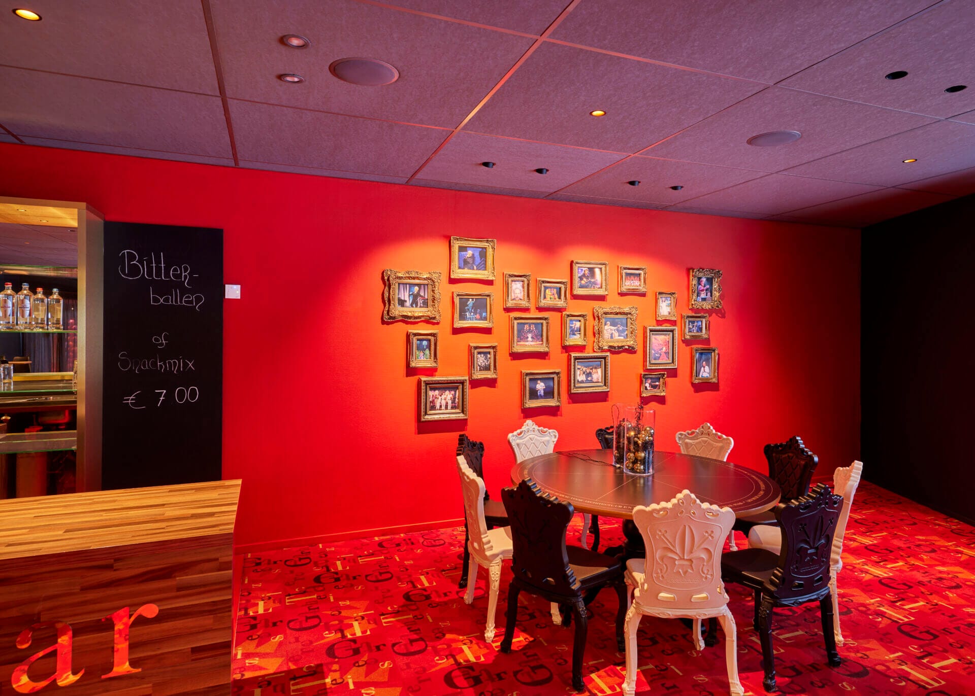 Theatre interior with a red wall with photo frames.