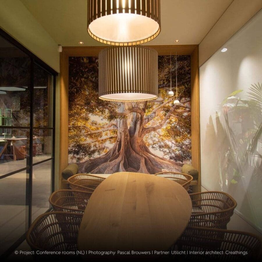 Modern meeting room with picture of a tree on the wall with DEA EROS S pe in pendants in white in front.