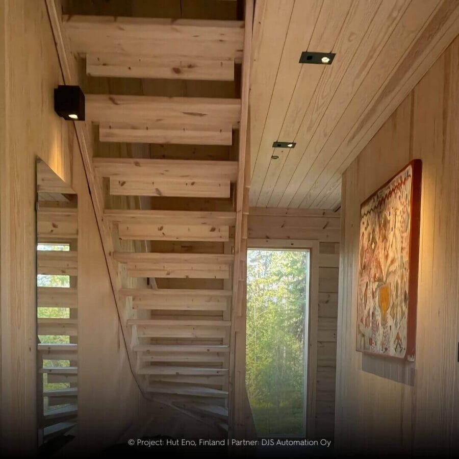 Hallway with Karizma Luce lighting in wooden cabin with forest view.